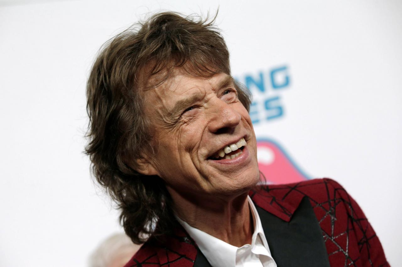 Mick Jagger of The Rolling Stones poses for photographers as the band arrives for the opening of the new exhibit "Exhibitionism: The Rolling Stones"in New York